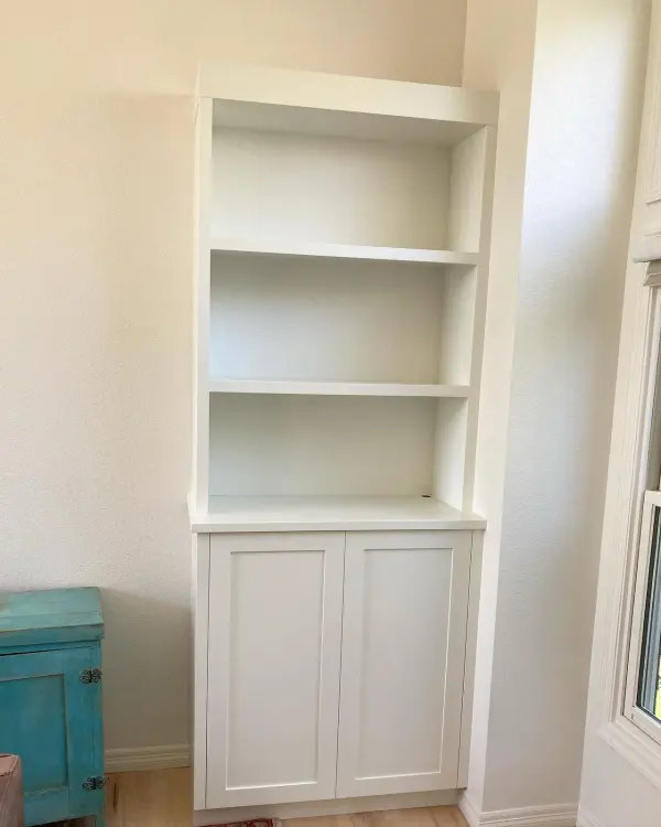 Painted built-in bookcase fitted into a wall alcove