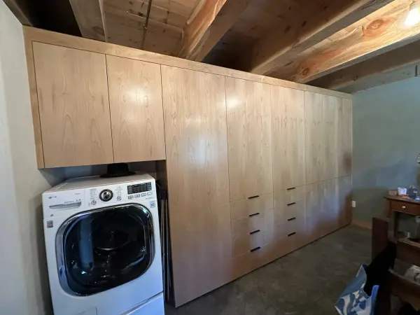 Floor to ceiling built-in storage wall in a laundry room