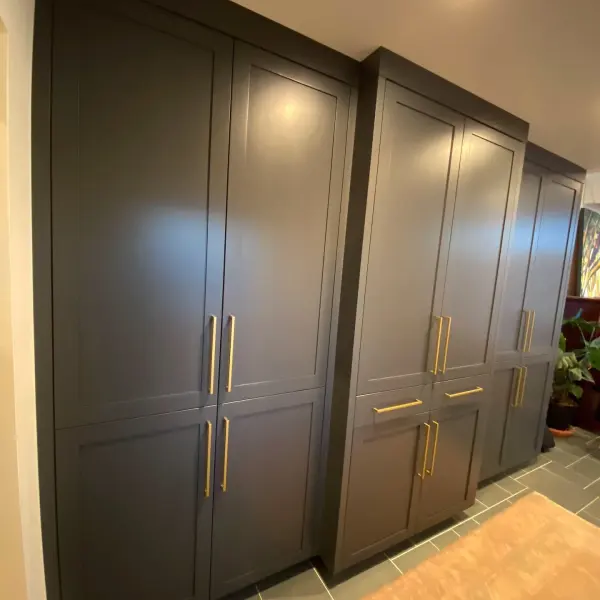 Tall painted built-in pantry cabinets with brass pulls