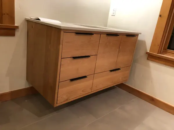Floating wood bathroom vanity with a stone top