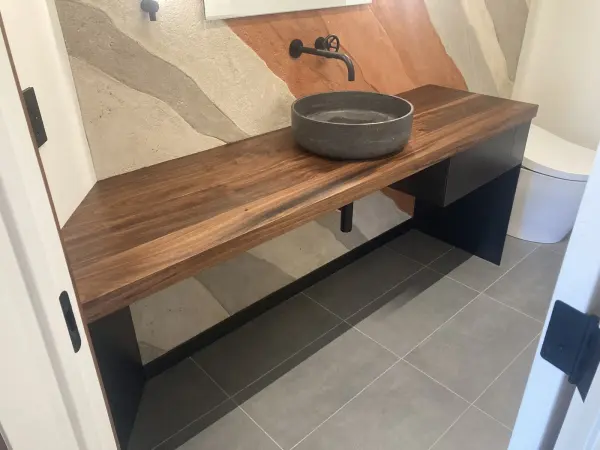Floating walnut custom bathroom vanity with a vessel sink