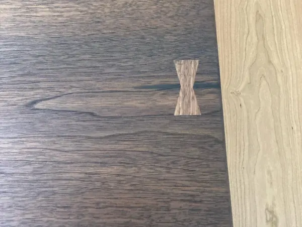 Contrasting bowtie inlay set into a walnut slab top