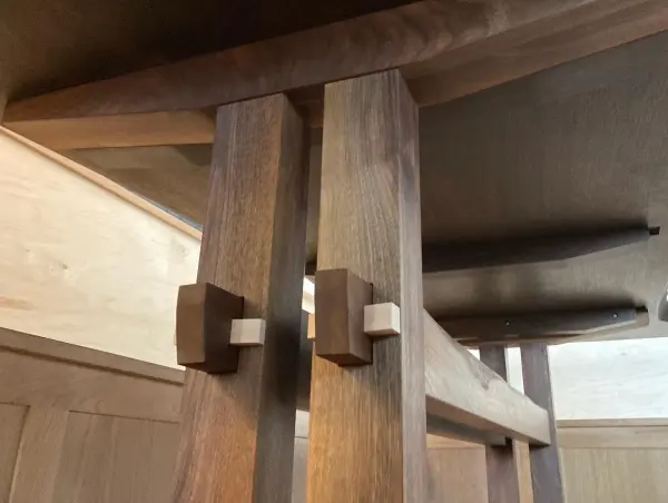 Close view of the joint on a walnut table base