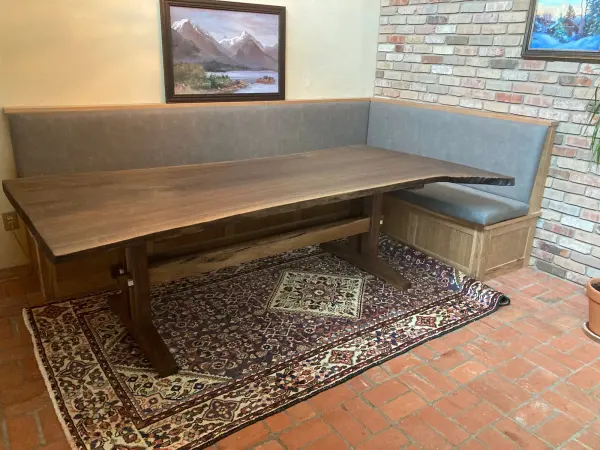 Live edge walnut slab dining table against a brick wall