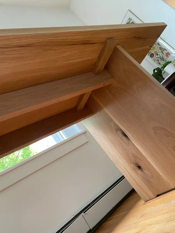 Mitered white oak corner joint on a built-in shelf near a window
